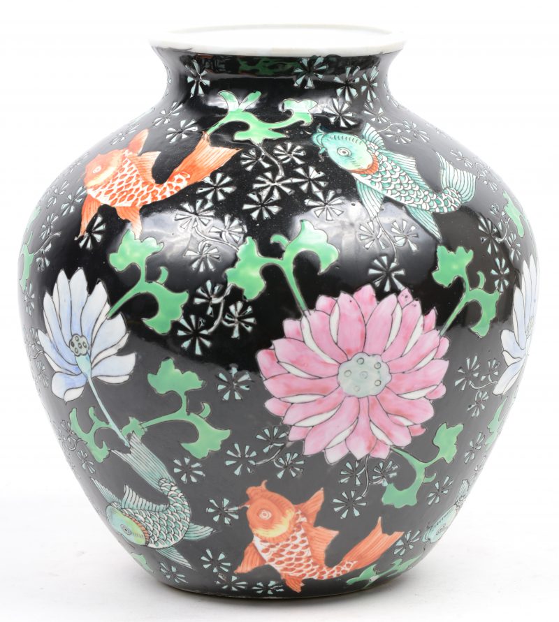 Een vaas van Chinees porselein met een famille-noiredecor van bloemen en vissen.