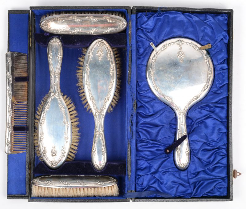Een Engelse Sterling zilveren set met vier borstels, een handspiegel en een kam. In etui.