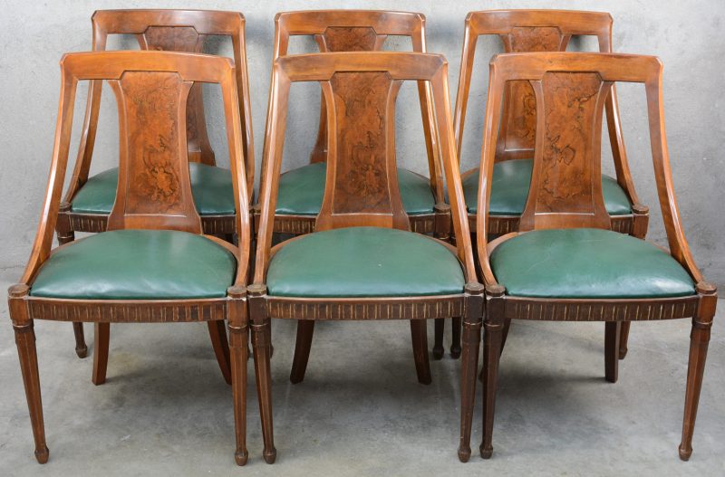 Een serie van zes notenhouten art deco stoelen, geïnspireerd op Régence voorbeelden. Wortelhouten details en groene lederen zittingen.