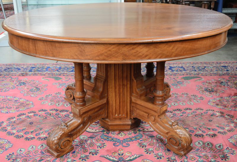 Een grote verlengbare tafel van gebeeldhouwd notenhout met centrale poot. Tijdperk Napoléon III. Zonder verlengbladen.