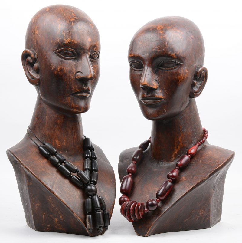 Een paar houten bustes met houten halssnoeren.