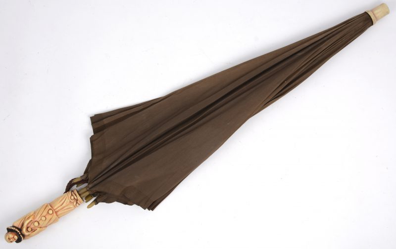 Een parasol met kunststoffen handvat in de vorm van een pierrot.
