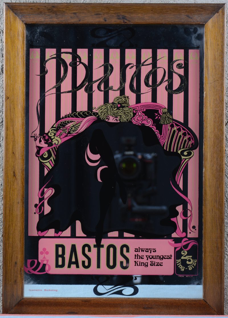 Een reclamespiegel voor Bastos in houten lijst.