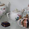 Een lot van twaalf meerkleurig porseleinen theepotjes naar voorbeeld uit het Victoria and Albert Museum. Onderaan gemerkt.