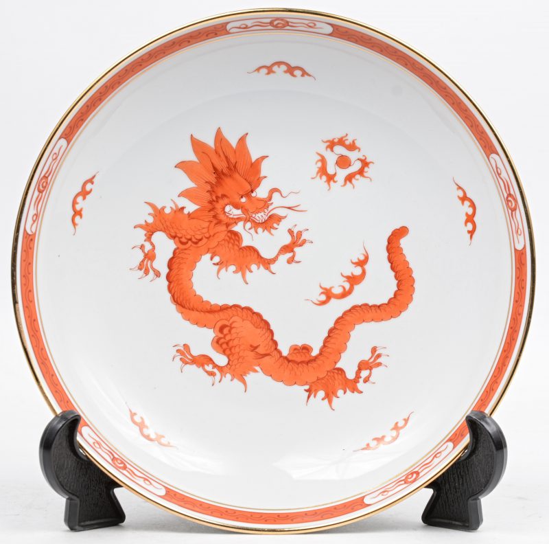 Een sierbord met een meerkleurig Japans decor van een draak. Onderaan gemerkt. Met staandertje.