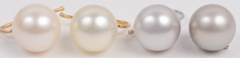 Een paar 18 karaats wit gouden oorbellen bezet met twee grijze parels en een paar 18 karaats geel gouden oorbellen bezet met twee witte parels.