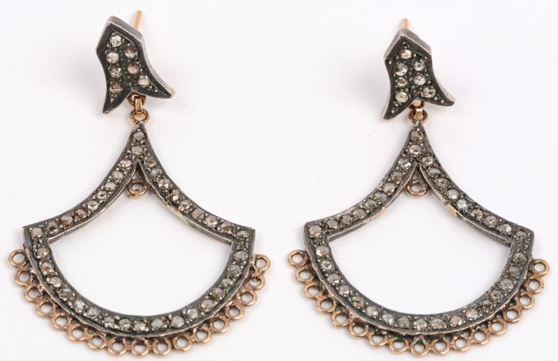 Een paar oorbellen van 18 karaats geel goud en zilver bezet met diamanten oude slijp met een gezamenlijk gewicht van +- 1,50 ct.