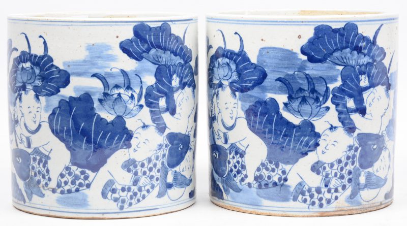 Een paar cilindervormige potten van Chinees porselein met een blauw op wit decor van zotjes.