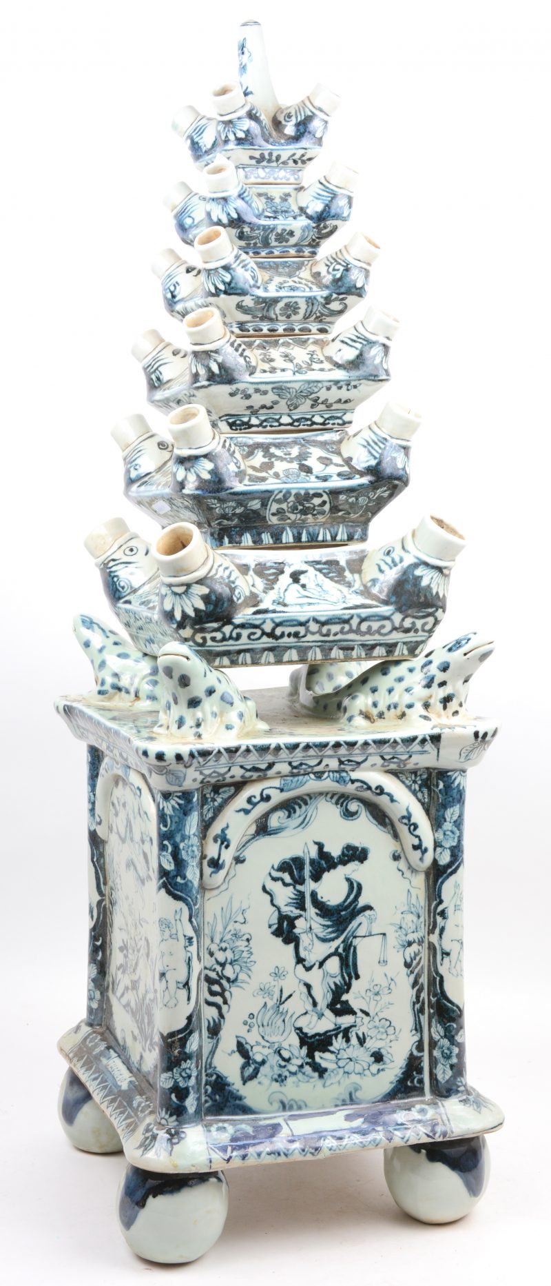 Een hoge tulpenvaas van blauw en wit Chinees porselein, opgebouwd uit zes delen op een basis met vier salamanders.