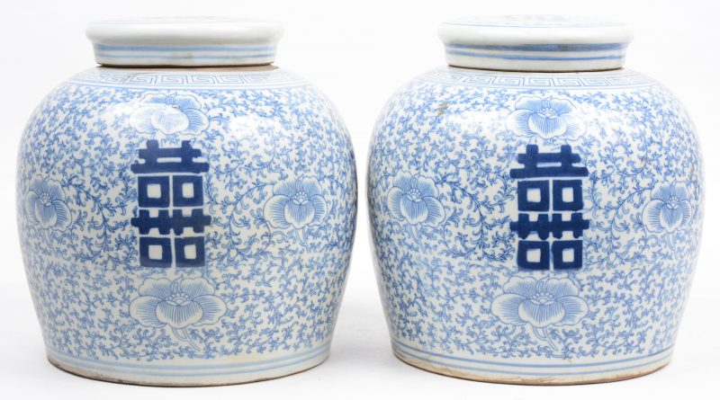 Een paar gemberpotten van Chinees porselein met een blauw op wit decor van gelukstekens en florale motieven.