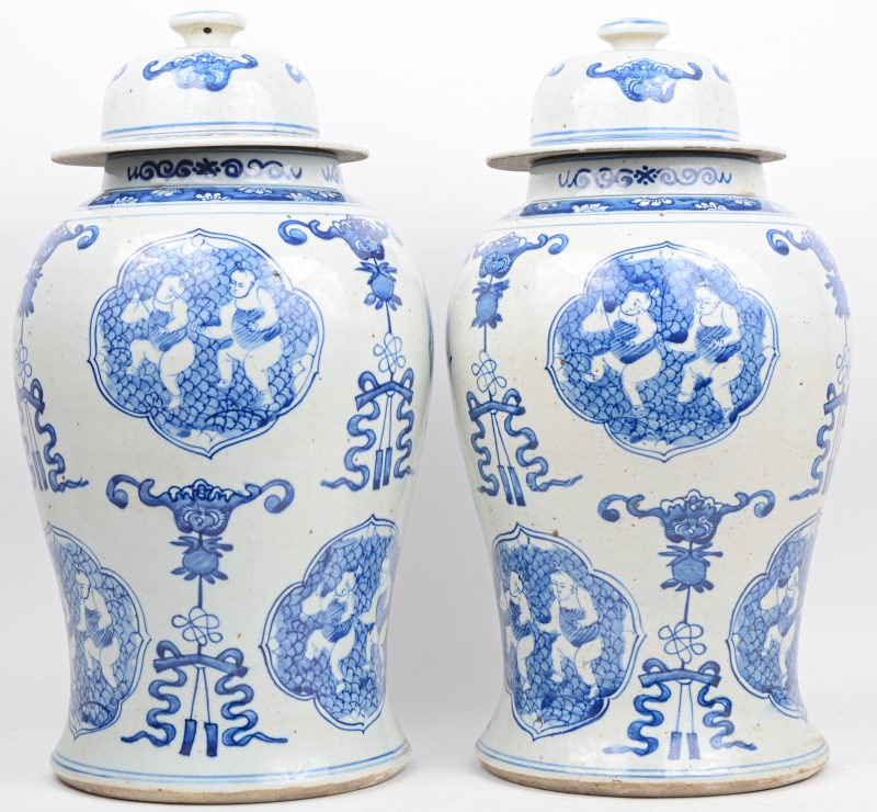 Een paar dekselvazen van Chinees porselein met een blauw op wit decor van zotjes.