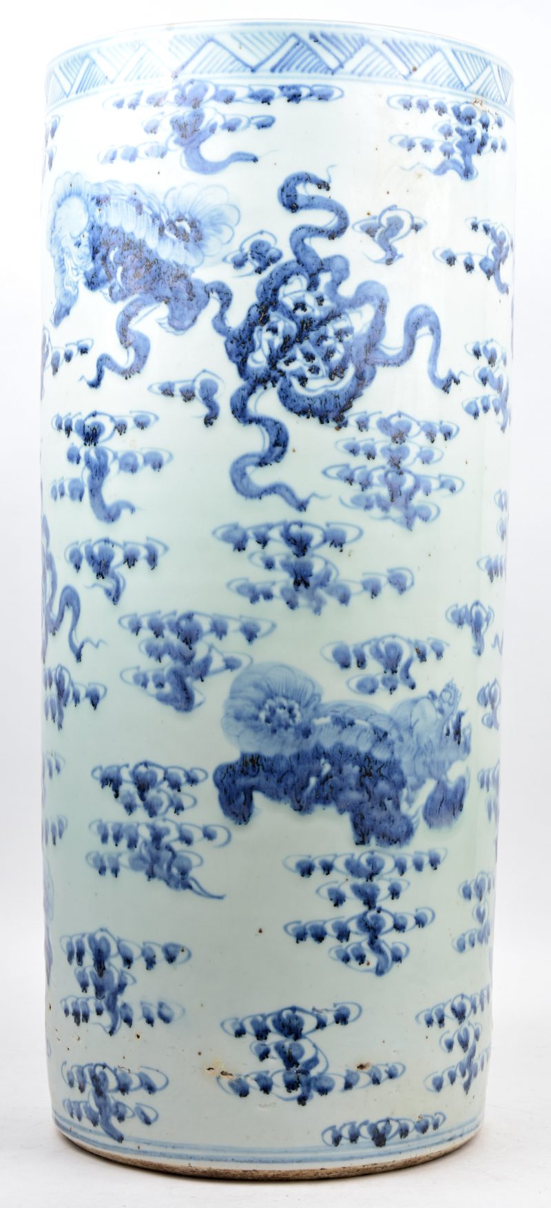 Een cilindervormoge paraplubak van Chinees porselein met een blauw op wit decor van Fo-honden.