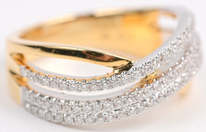 Een 18 karaats wit en geel gouden ring bezet met briljanten met een gezamenlijk gewicht van +- 0,46 ct.
