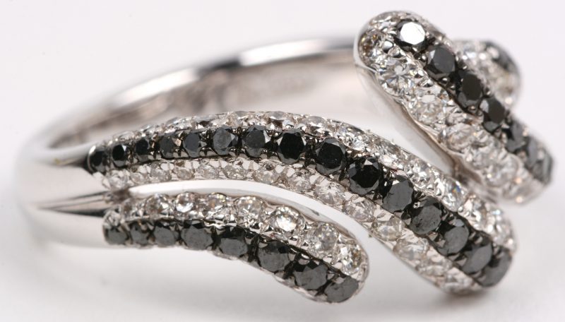 Een 18 karaats wit gouden ring bezet met witte en zwarte diamanten met een gezamenlijk gewicht van +- 1,77 ct.