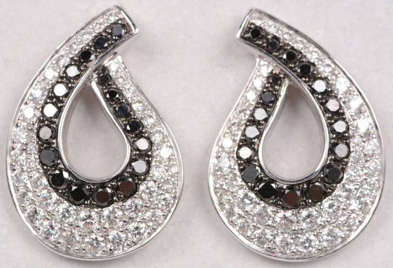 Een paar 18 karaats wit gouden oorbellen bezet met witte en zwarte diamanten met een gezamenlijk gewicht van +- 1,08 ct.