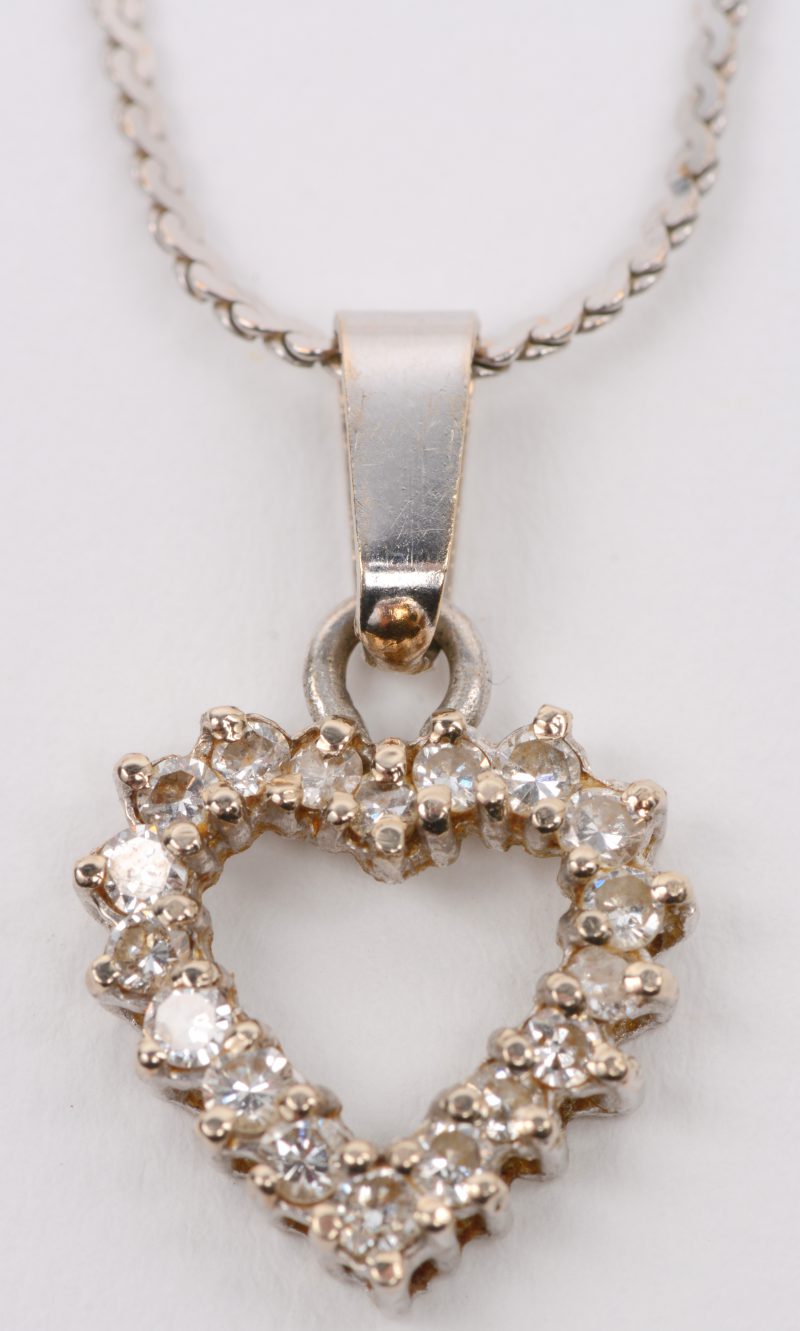 Een 18 karaats wit gouden ketting met hanger in de vorm van een hart bezet met een briljanten met een gezamenlijk gewicht van +- 0,50 ct.