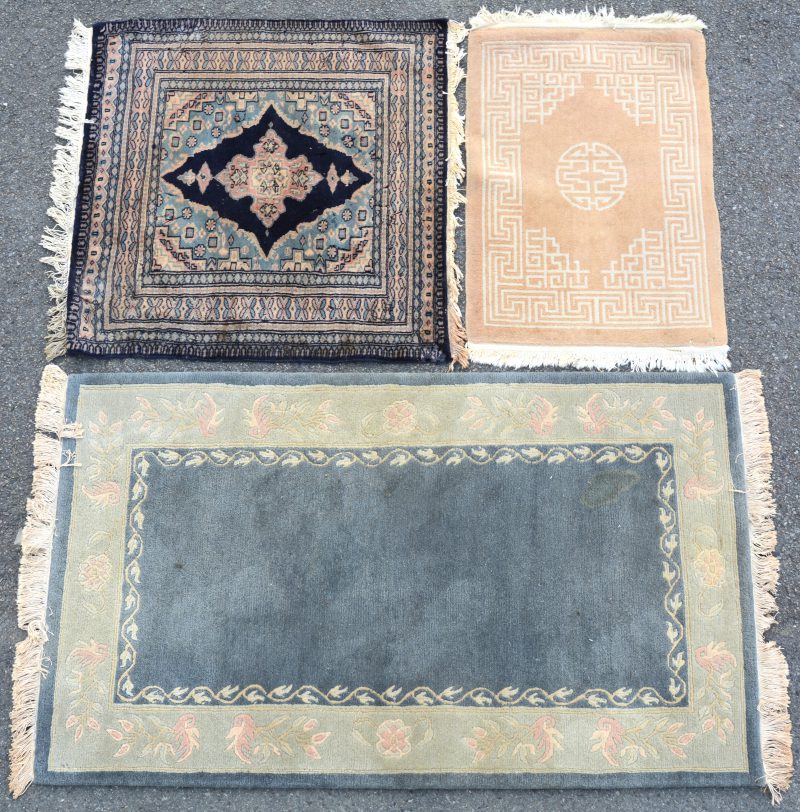 Drie handgeknoopte wollen karpetjes, waarbij twee Nepalese en één Pakistaans.