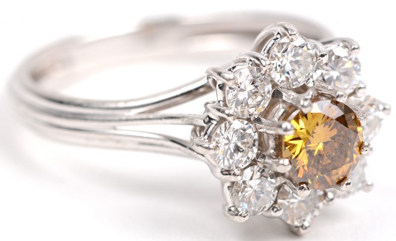 Een 18 karaats wit gouden ring bezet met briljanten met een gezamenlijk gewicht van +- 0,80 ct. en een centrale gele diamant van +- 0,65 ct.