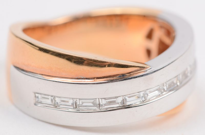Een 18 karaats wit en geel gouden ring bezet met briljanten met een gezamenlijk gewicht van +- 0,42 ct.