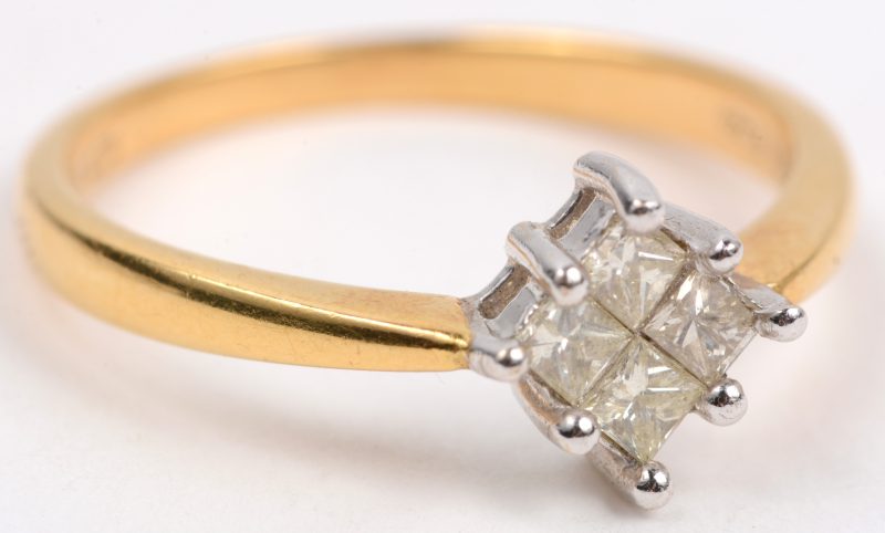 Een 18 karaats wit en geel gouden ring bezet met vier diamand princessen met een gezamenlijk gewicht van +- 0,40 ct.