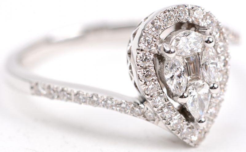 Een 18 karaats wit gouden druppelvormige ring bezet met vier diamant markiezen, één baguet en briljanten met een gezamenlijk gewicht van +- 0,80 ct.