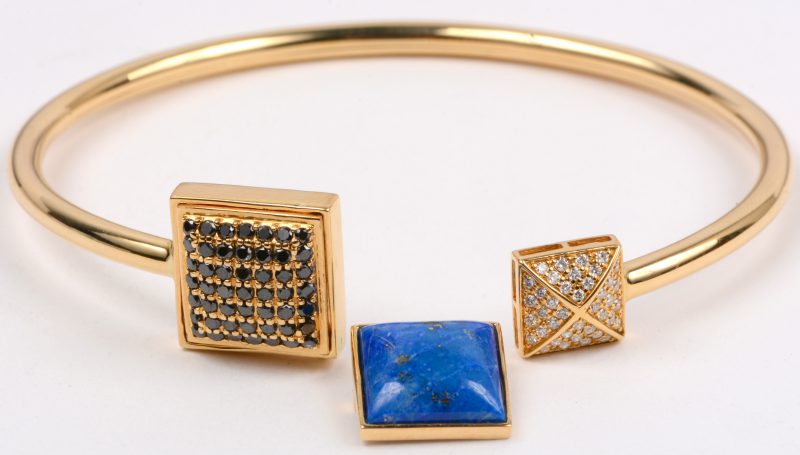 Een 18 karaats geel gouden armband bezet met zwarte diamanten met een gezamenlijk gewicht van +- 1 ct. en briljanten met een gezamenlijk gewicht van +- 0,40 ct. en een vervangbare lapis lazuli.