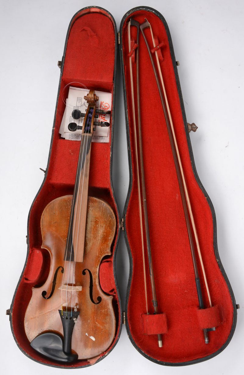 Een viool met vioolkast en strijkstokken. Slijtage, maar intact.