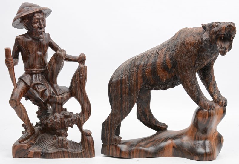 Een tijger en een visser. Twee Oosterse sculpturen van exotisch hout.