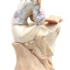 “Zittende jonge vrouw met boek”. Een beeldje van meerkleurig biscuit naar ontwerp van Vittorio Sabadin. Gemerkt.