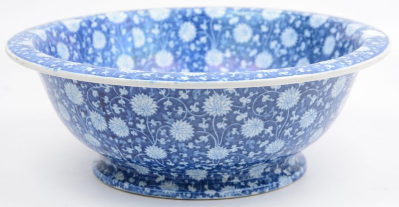 Een diepe schaal van Chinees porselein met een blauw en wit floraal decor.