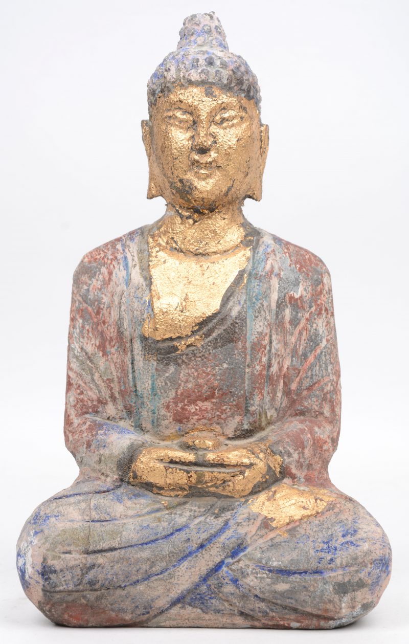 Een gepolychromeerde stenen Nepalese Boeddha.