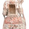 Een antiek houten Boeddhabeeld met sporen van polychromie en met opening in de rug. Op sokkel.