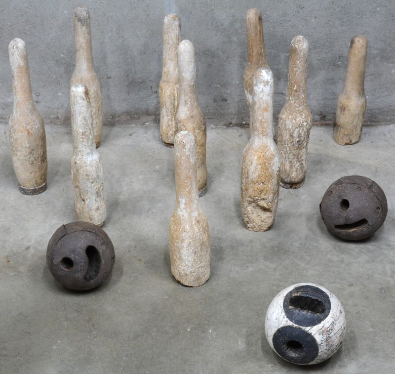 Een antiek kegelspel, bestaande uit tien (verweerde) kegels en drie ballen.