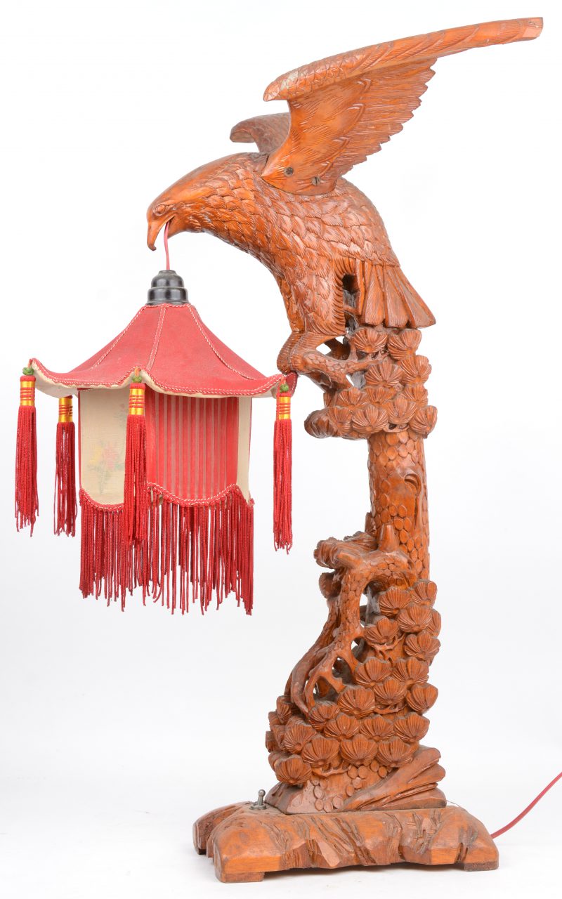Een gebeeldhouwd houten lampvoet, getooid met een adeleer met een lampion in de bek. Chinees werk.