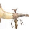 Een runderhoorn met bronzen montuur en voet, versierd met een ramskop en gedragen door een putto. XIXe eeuw. Te restaureren.