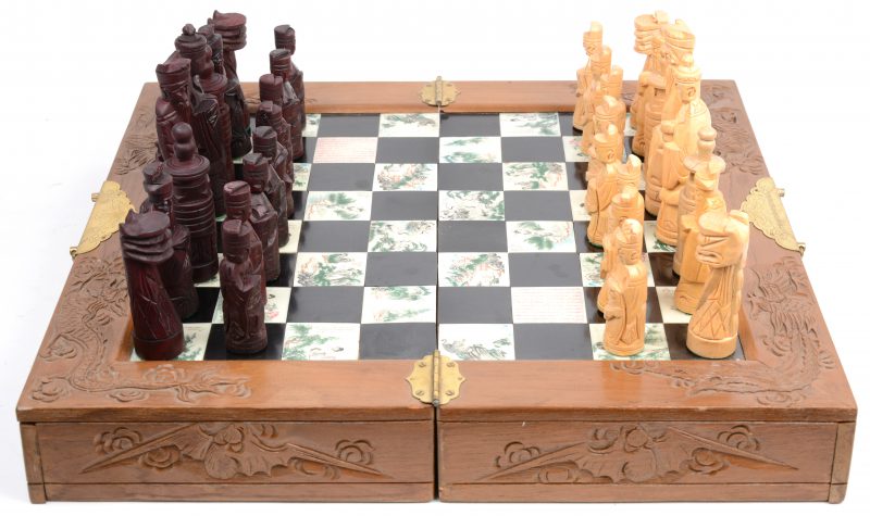 Een Chinese schaakset met gesneden houten stukken.