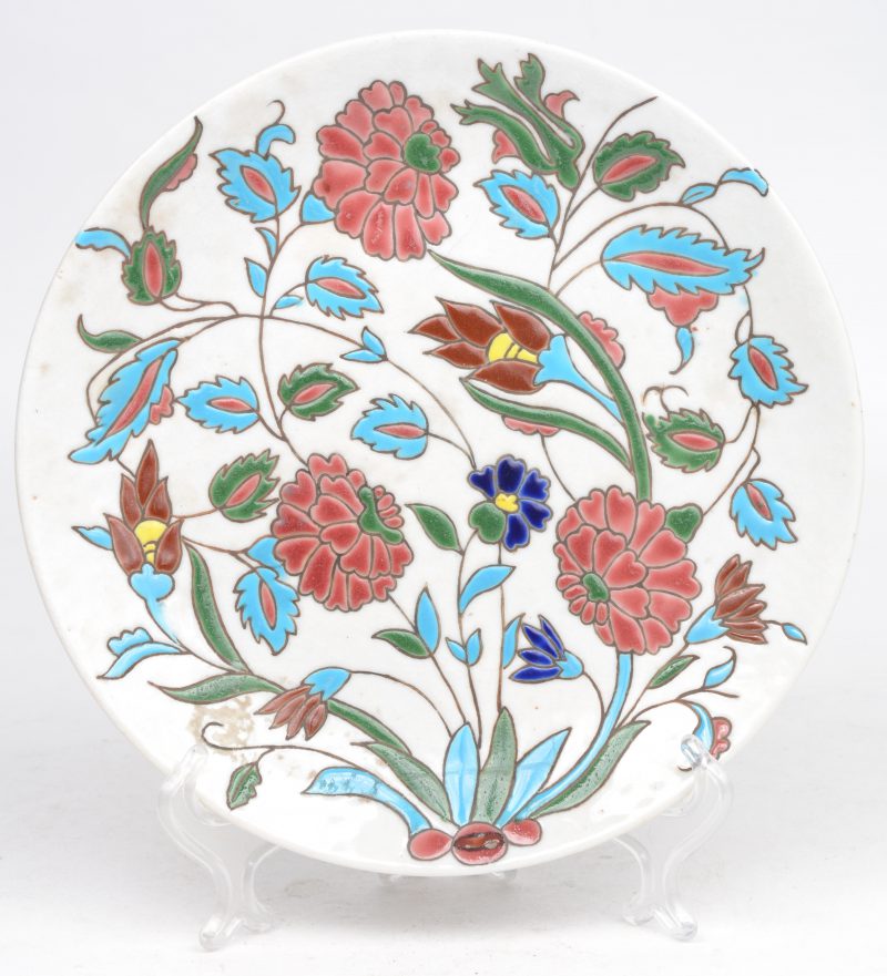 Een sierbord van Turks porselein met een meerkleurig reliëfdecor van bloemen.
