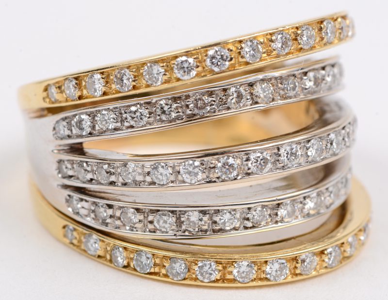 Een 18 karaats wit en geel gouden ring bezet met briljanten met een gezamenlijk gewicht van +- 1 ct.
