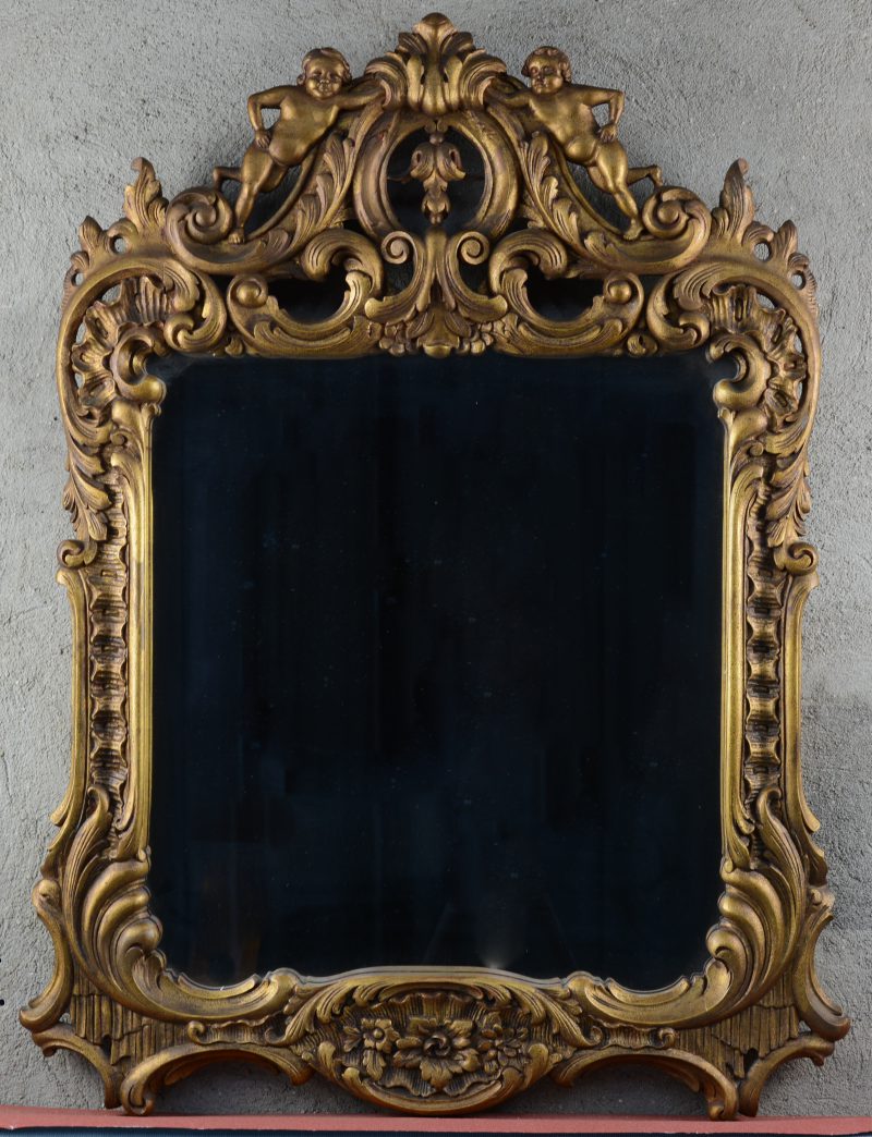 Een houten spiegel in barokke stijl.