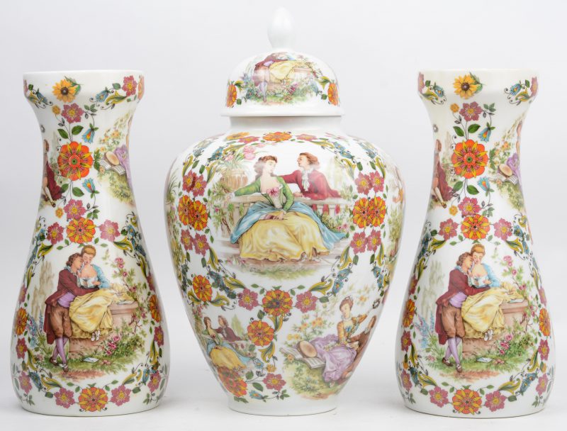 Een driedelig kaststel van porselein, versierd met meerkleurig decor van koppels tussen bloemen. Onderaan gemerkt.