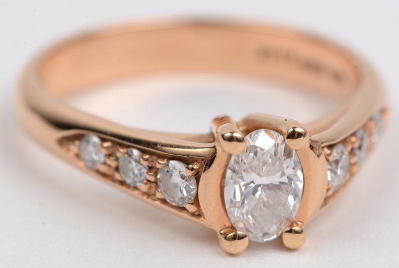 Een 18 karaats roze gouden ring bezet met een diamant markies van +- 0,46 ct. DVVS2. en briljanten met een gezamenlijk gewicht van +- 0,26 ct.