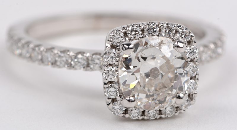 Een 18 karaats wit gouden ring bezet met een centrale diamant oude slijp van +- 1,17 ct. SI2. en briljanten met een gezamenlijk gewicht van +- 0,43 ct.