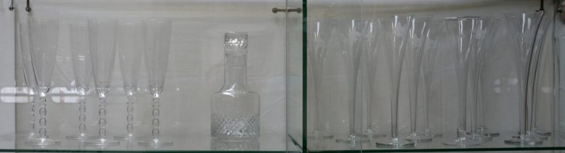 Een lot van twaalf antieke glazen fluitglazen, waarbij elf met Franse lelie, zes kristallen champagneglazen met ‘2000’ in de voet en een geslepen kleurloze karaf.