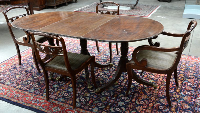 Een verlengbare Engelse tafel met vier bijpassende stoelen, waarvan twee armstoelen.