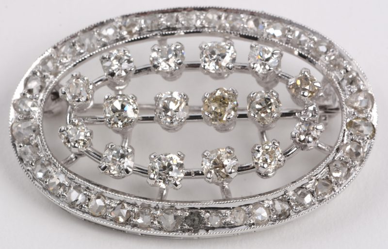 Een 18 karaats wit gouden broche bezet met briljanten en diamanten oude slijp met een gezamenlijk gewicht van +- 3 ct.
