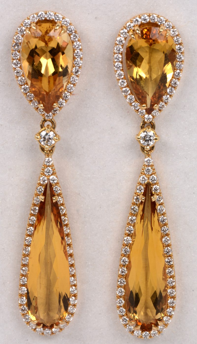 Een paar 18 karaats wit gouden oorbellen bezet briljanten met een gezamenlijk gewicht van +- 1,50 ct. en yellow berille met een gezamenlijk gewicht van +- 25,47 ct.