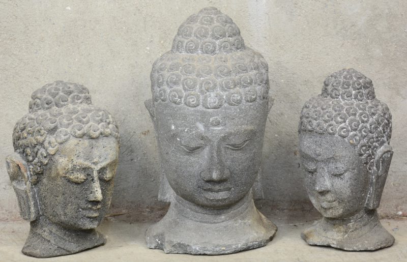 Een lot van drie stenen Boeddha-hoofden.