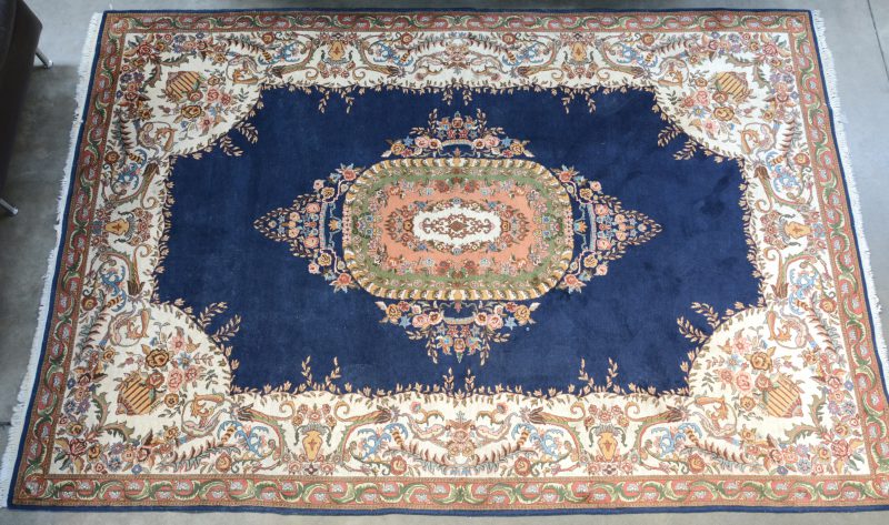 Een handgeknoopt wollen tapijt met bloemendecor.
