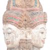 Een gepolychromeerd stenen Boeddhahoofd met drie gezichten. Op houten sokkel.