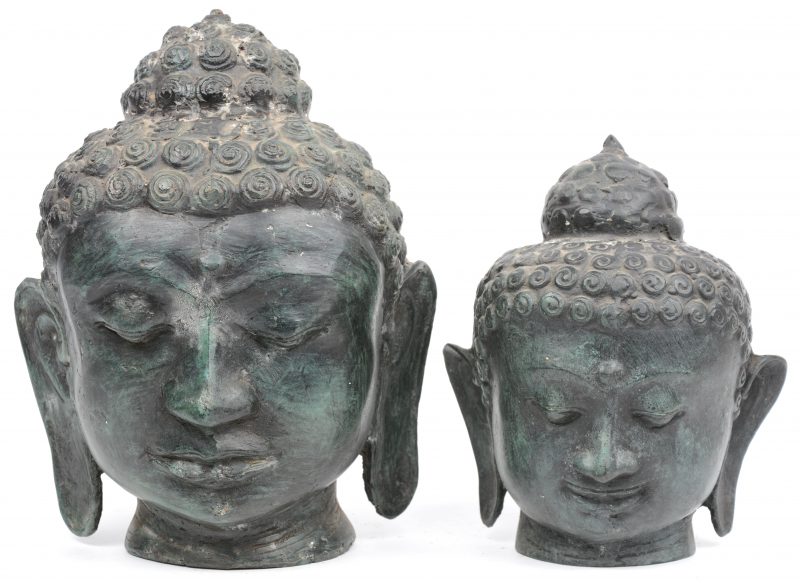 Twee bronzen Boeddhahoofden.